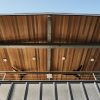 Looking up at the lanai, Modern Fan IC/Air3 fans, Rich Brilliant Willing Seed lights, steel structure and railing by Hawaii Off-Grid. Cedar T&G, board and batten installed by Massimo Pandolfi
